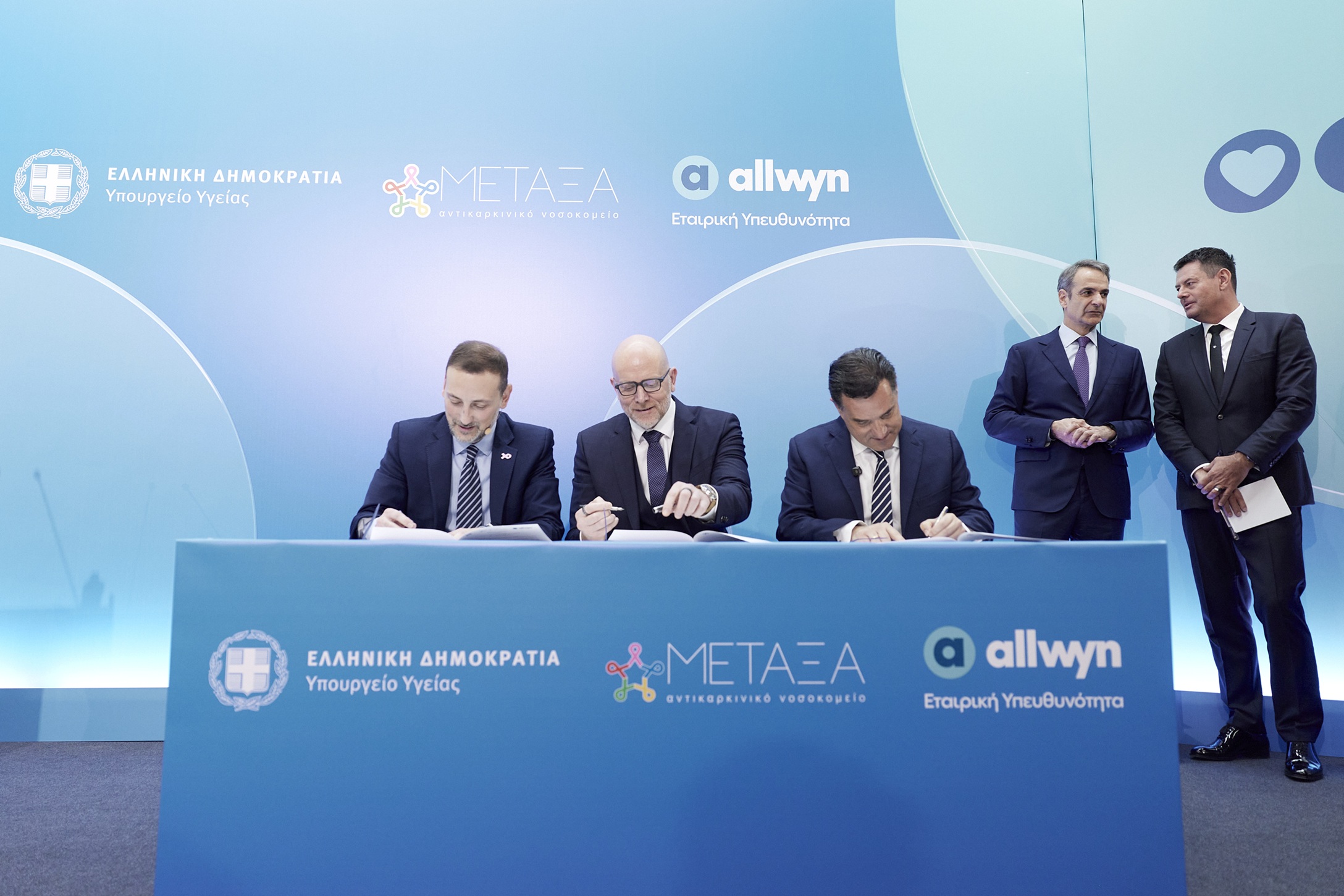 6 Υπογραφή μνημονίου συνεργασίας από τους Σαράντο Ευσταθόπουλο, Διοικητή του Αντικαρκινικού Νοσοκομείου «Μεταξά», Jan Karas, Πρόεδρο και Διευθύνοντα Σύμβουλο της Allwyn στην Ελλάδα και Άδωνι Γεωργιάδη, Υπουργό Υγείας, παρουσία του Πρωθυπουργού, Κυριάκου Μητσοτάκη και του Ιδρυτή και Προέδρου της Allwyn, Karel Komarek