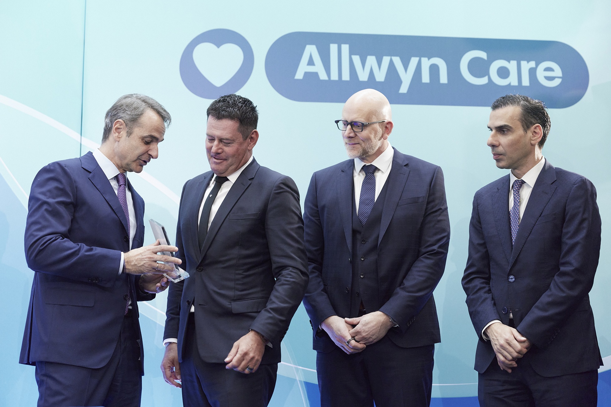 O Πρωθυπουργός, Κυριάκος Μητσοτάκης, παραδίδει αναμνηστικό δώρο στον Karel Komarek, Ιδρυτή και Πρόεδρο της Allwyn, παρουσία του Jan Karas, Πρόεδρου και Διευθύνοντος Σύμβουλου της Allwyn στην Ελλάδα και του Υφυπουργού Υγείας, Μάριου Θεμιστοκλέους